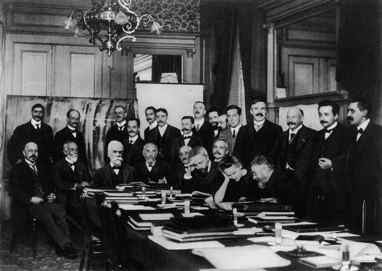 Photographie de groupe du premier conseil Solvay de 1911, une vingtaine de physiciens autour d’une table